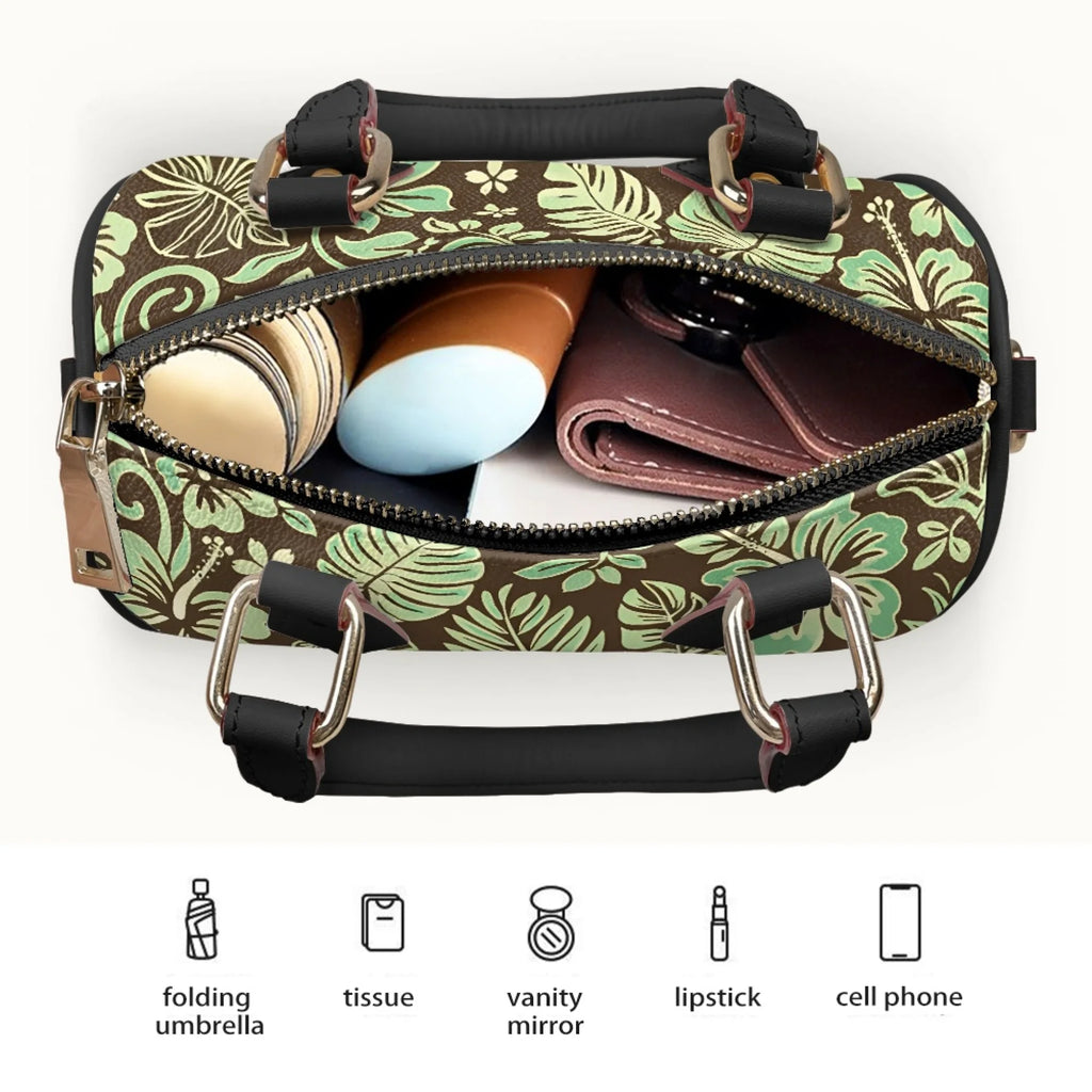 Tropical print pillow-shaped trunk handbag in brown and mint green with black top handles and gold hardware.