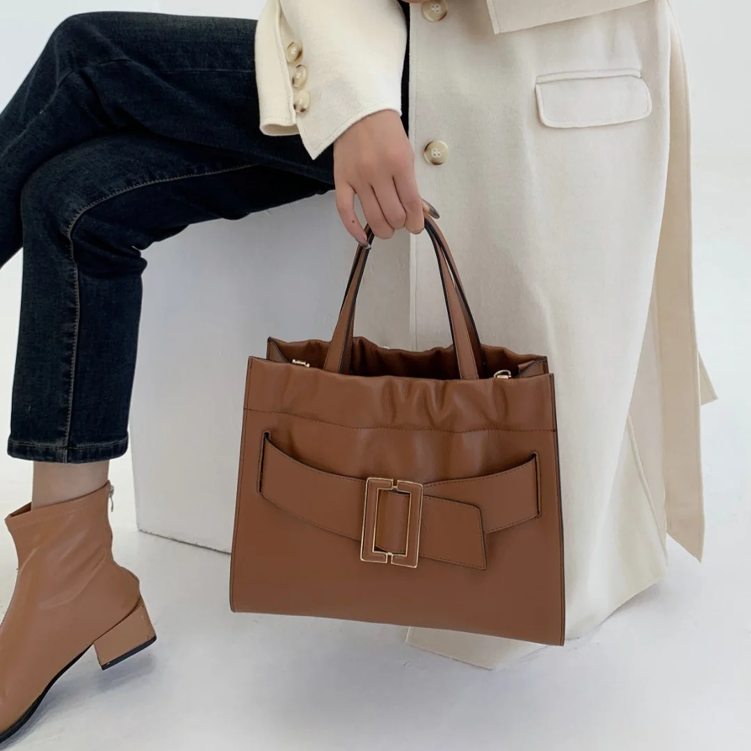 Brown genuine leather tote handbag with gold buckle strap detail, large capacity, and top handles for work.