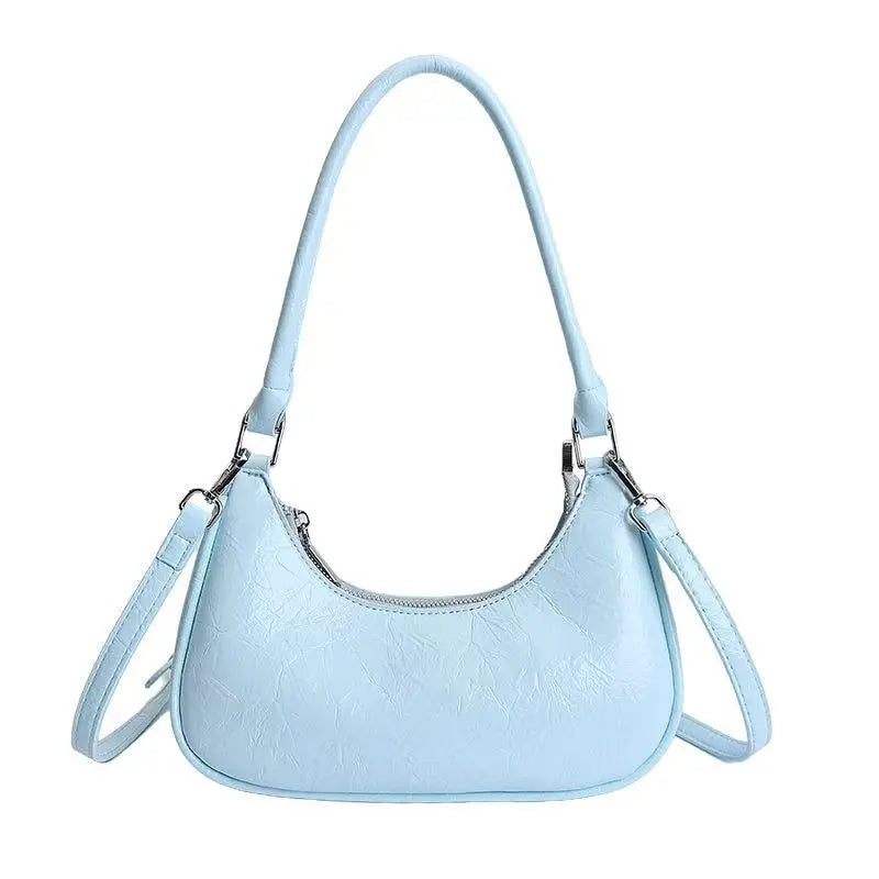 Light blue textured leather dumpling bag, versatile shoulder and crossbody trunk style with zip top and silver hardware.