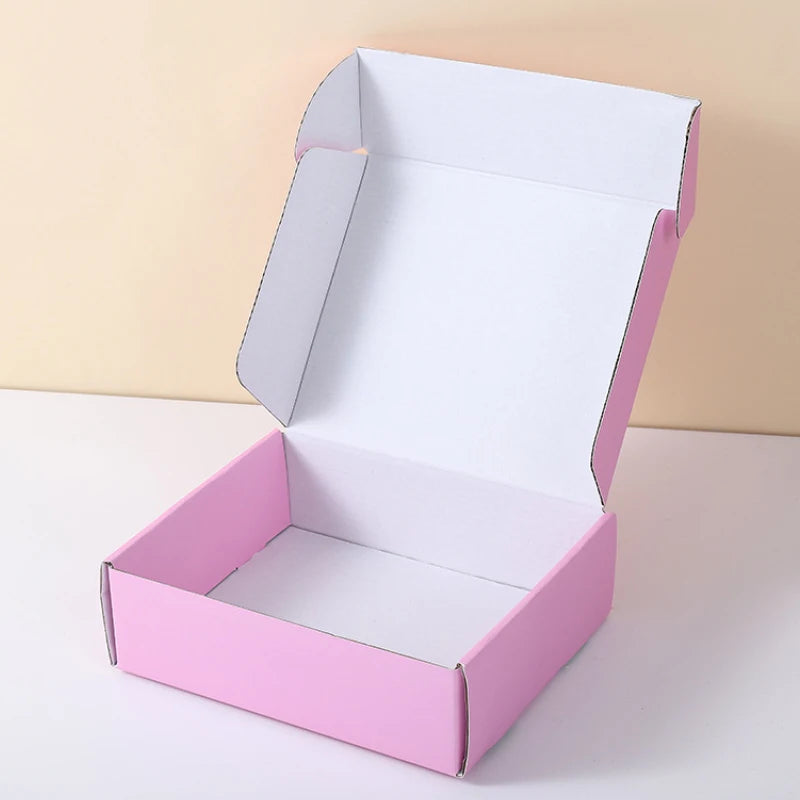 White and pink mailer box with open lid and flat base, shipping packaging