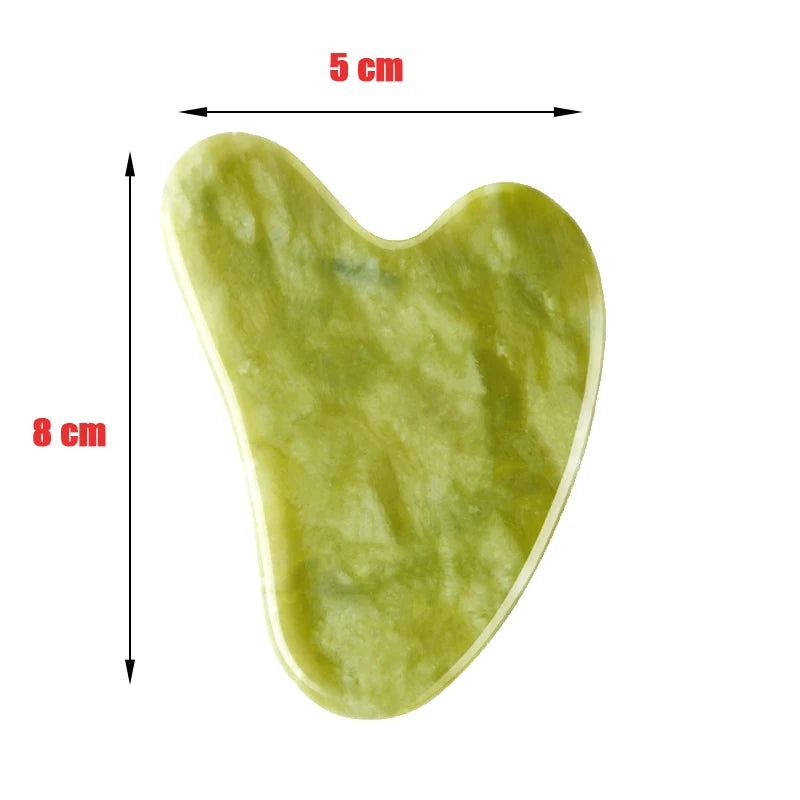 Heart-shaped light green jade gua sha facial massage tool, 5 cm wide and 8 cm long, isolated on a white background.