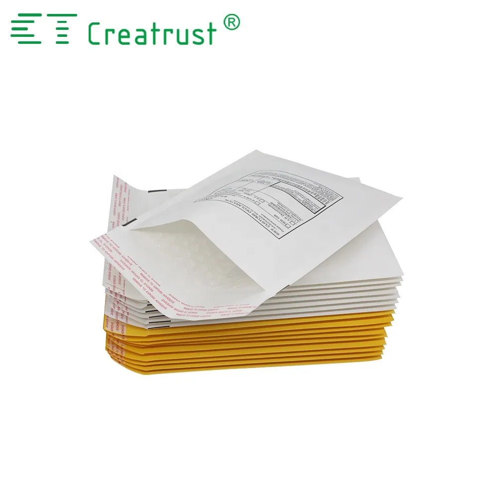 Stack of white padded mailer envelopes with printed label on top over yellow stack