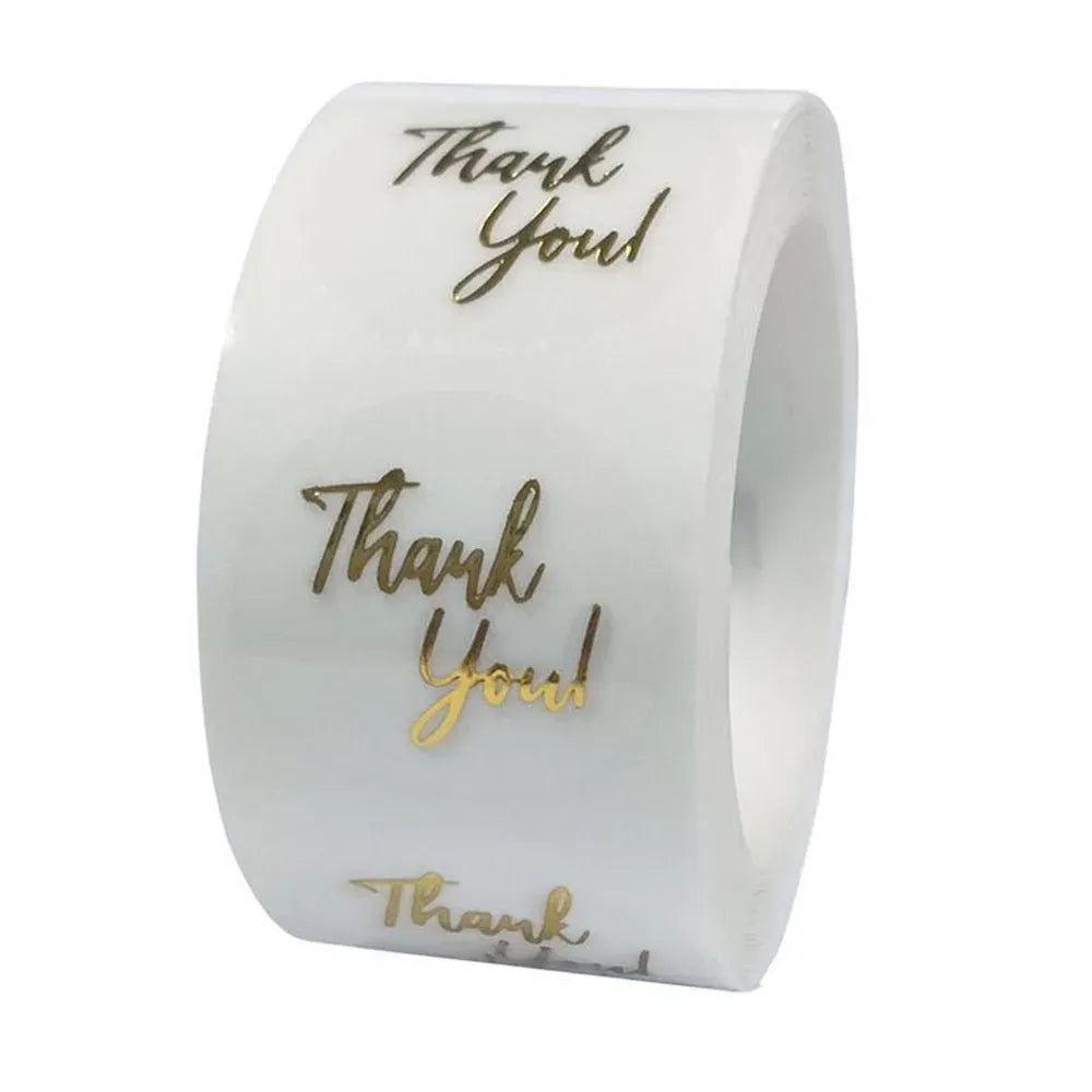 Thank you label stickers on a roll, gold script “Thank You” on white backing