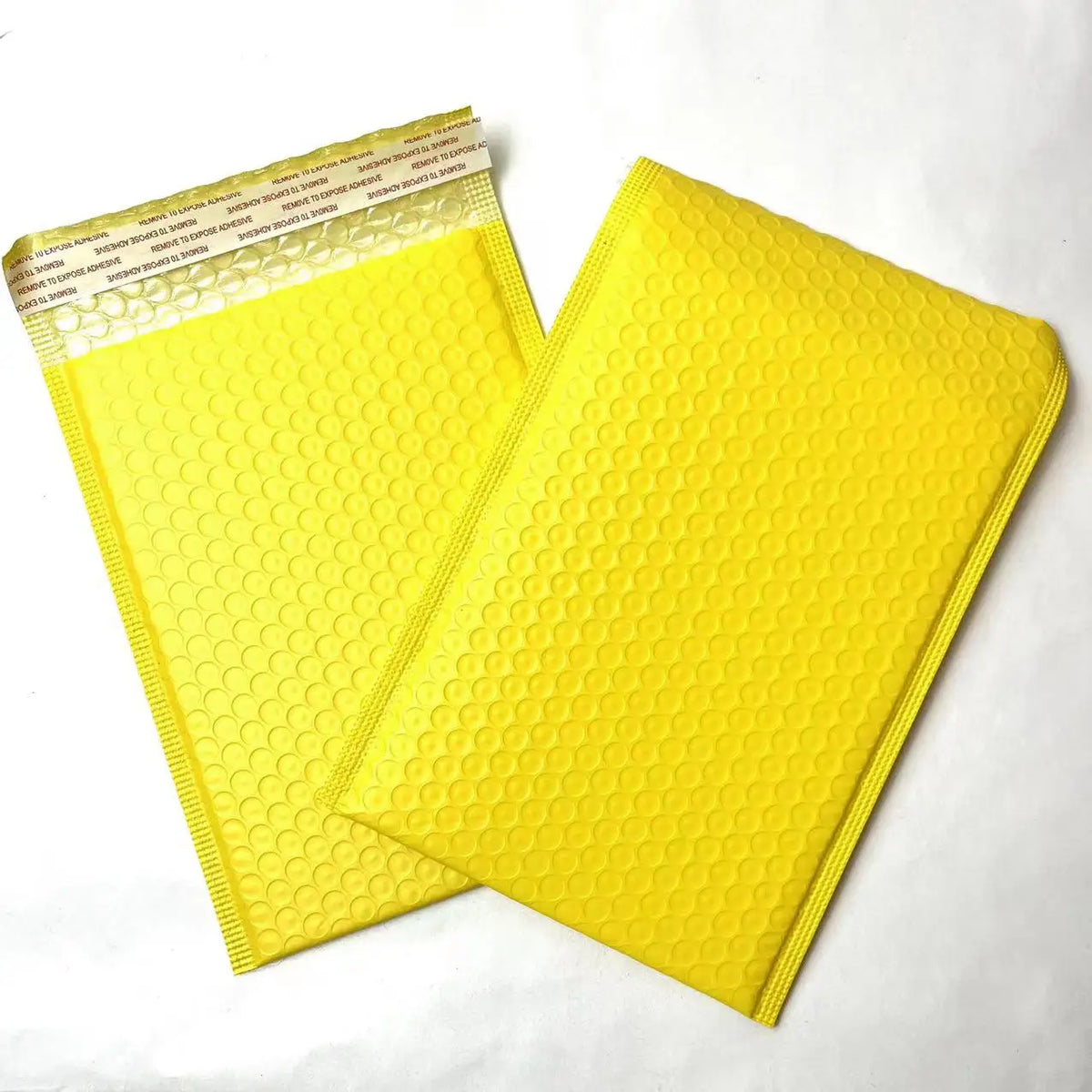 Yellow bubble mailer shipping bags with raised bubble-texture poly surface.