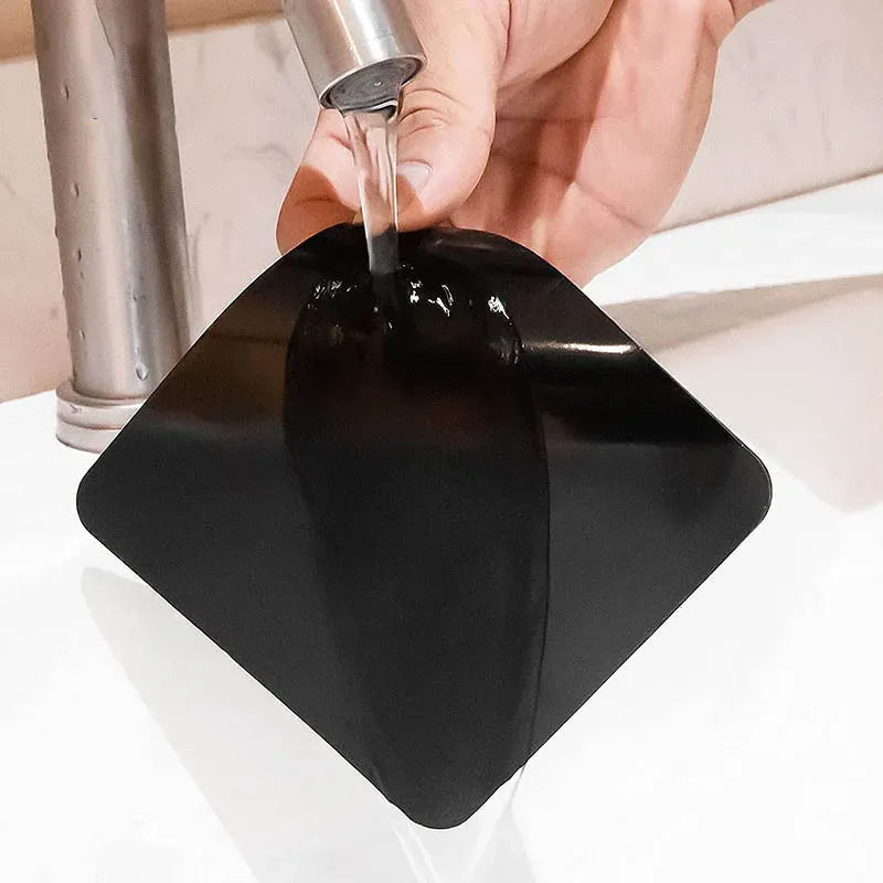 Black double-sided carpet grip pad with protective film being peeled by hand