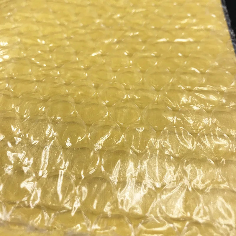 Yellow bubble wrap interior layer with raised cushioning texture