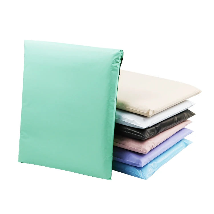 Stack of waterproof poly mailer bags in mint, cream, black, mauve, and blue