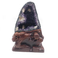 Purple amethyst geode decoration with a carved brown base and embossed floral designs