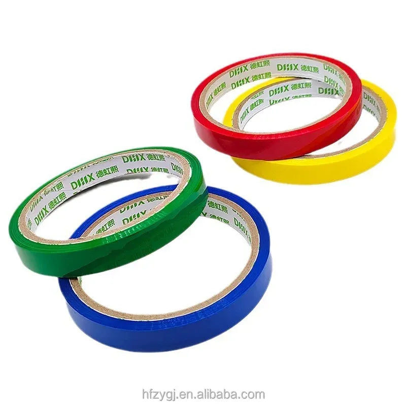 Set of strapping tape rolls in green, blue, red, and yellow with printed inner core