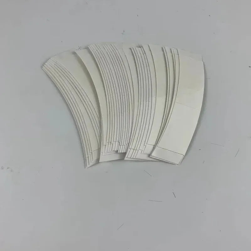White double-sided adhesive tape strips, fanned in a stack
