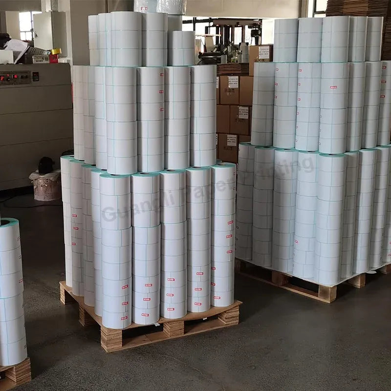 Stacked white thermal label rolls on pallets