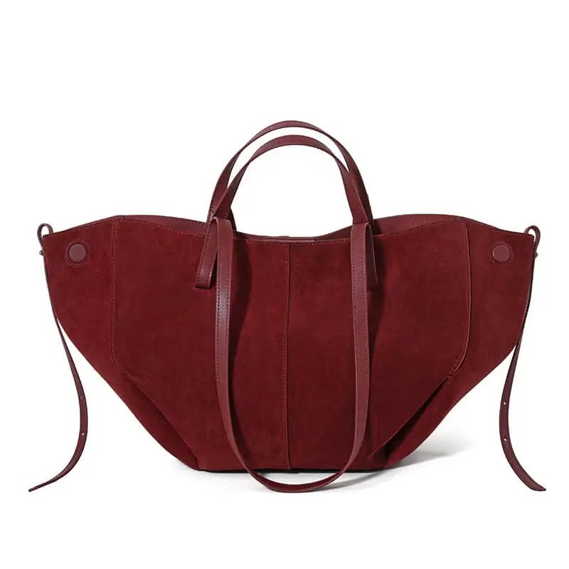 Burgundy suede designer handbag with a wide, slouchy silhouette, dual handles, and side strap details.
