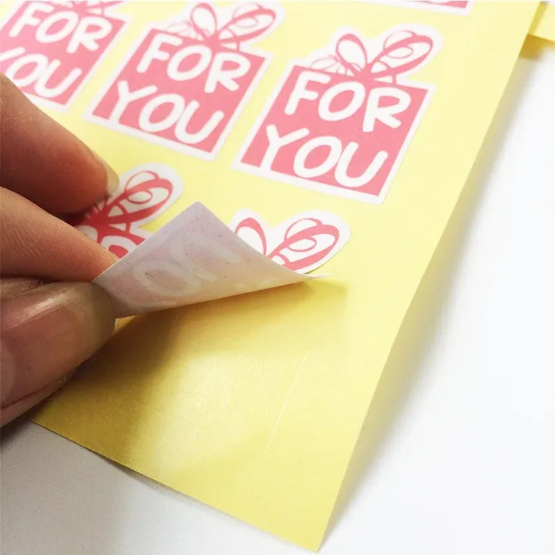 Pink 'For You' sealing sticker being peeled, gift-box and bow design