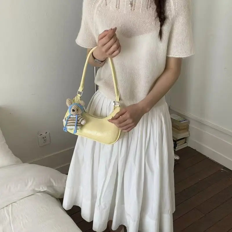 Yellow dumpling-shaped shoulder bag in waterproof leather with a cute bear charm, elegant handbag for women.