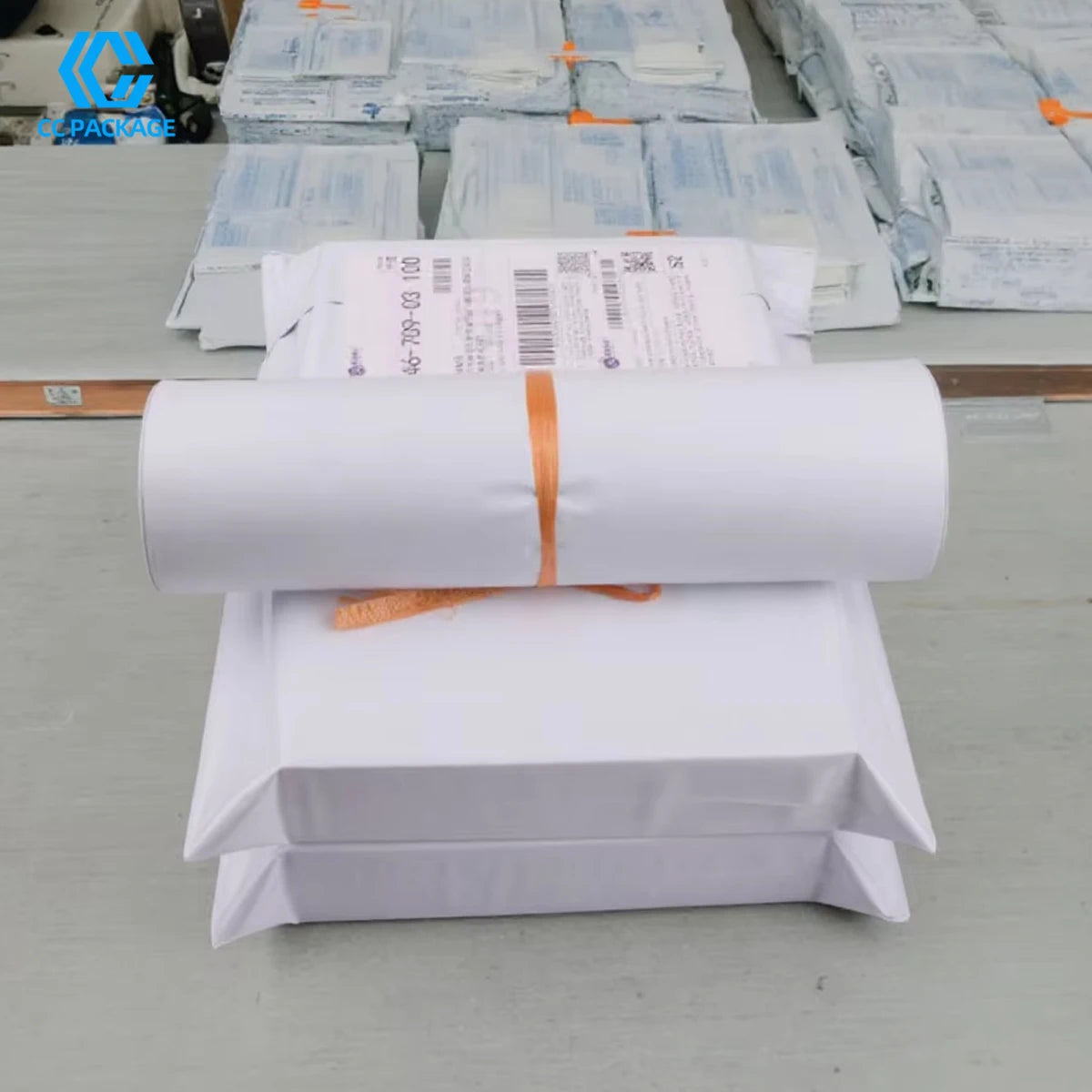 White padded poly mailers on rolls with orange tie bands