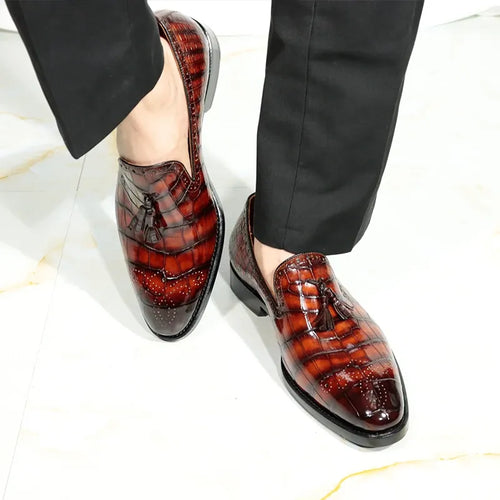 Luxury brown crocodile-embossed leather tassel loafers with brogue details and stacked heels for men.