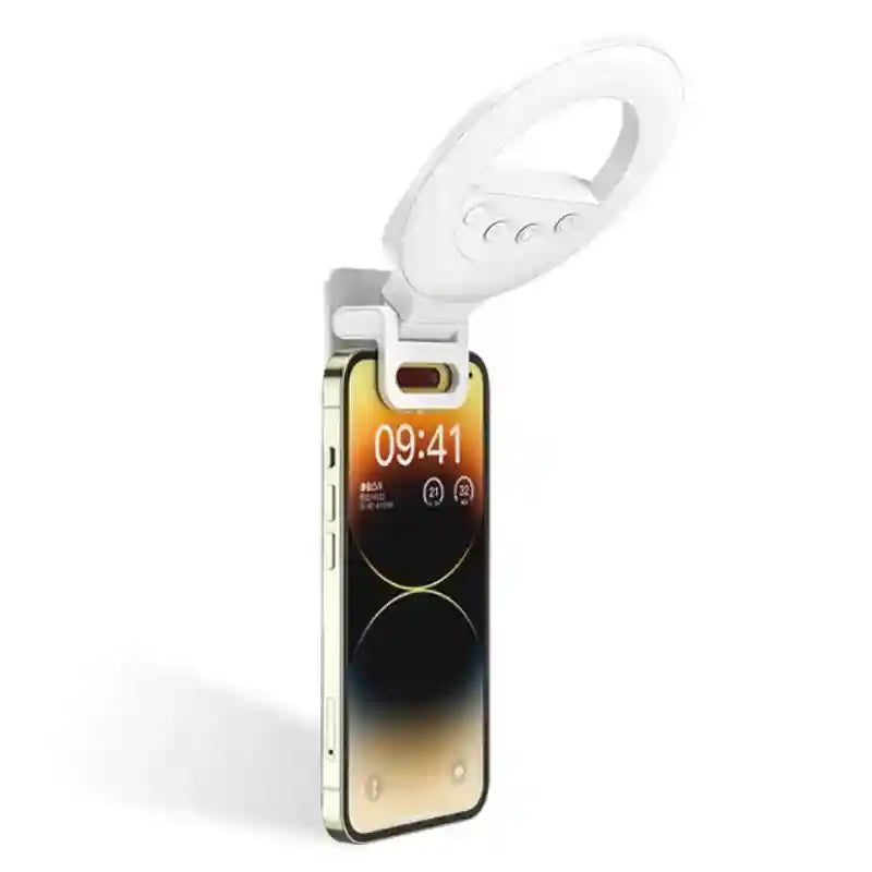 White circular LED clip-on ring light attached to the top of a smartphone for selfie illumination.