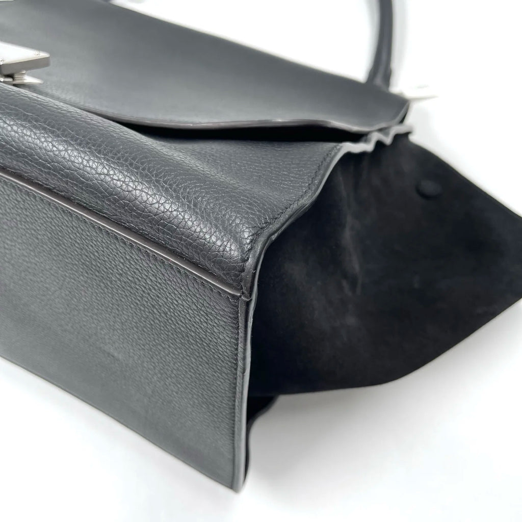 Classic black designer shoulder bag in lychee texture leather with distinctive swing side design and vintage elegance.