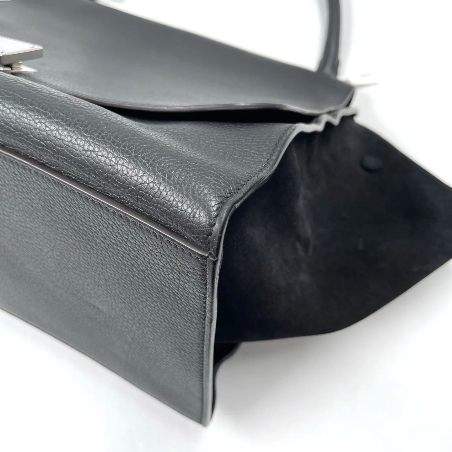 Classic black designer shoulder bag in lychee texture leather with distinctive swing side design and vintage elegance.