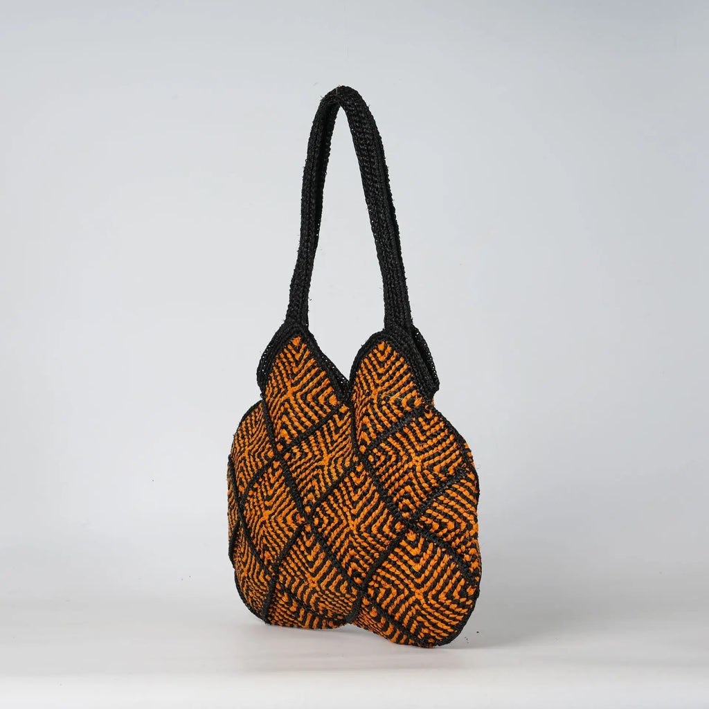 Boho black and orange crochet tote bag with geometric diamond patterns and sturdy woven handles for summer beach use.