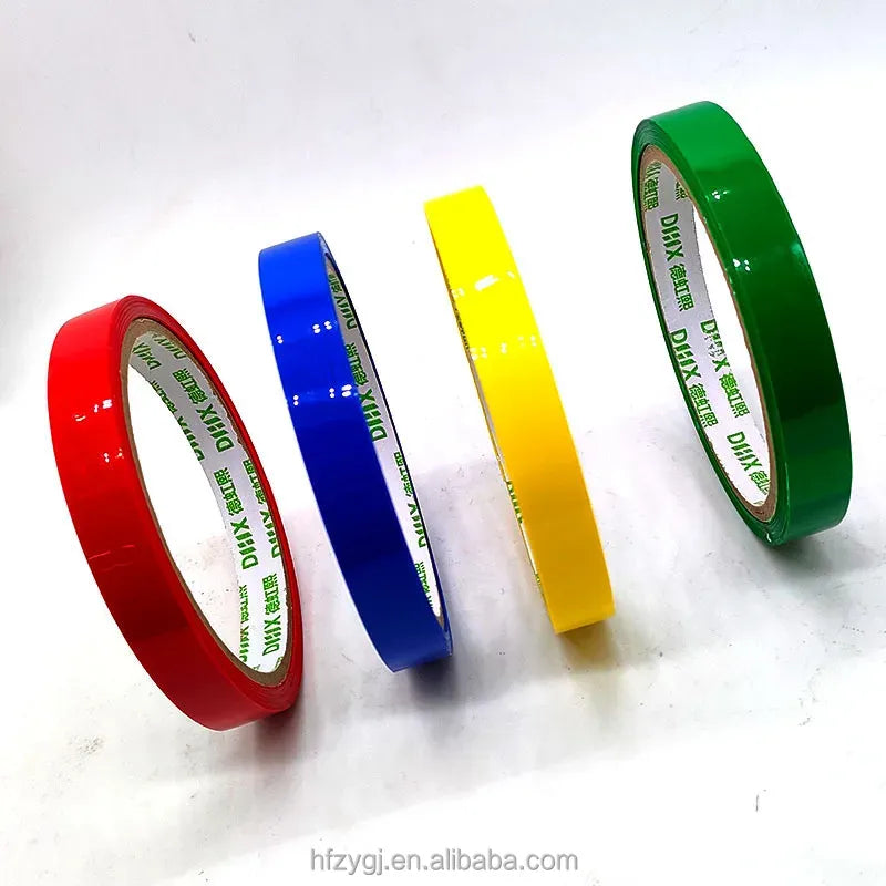 Assorted colored strapping tape rolls: red, blue, yellow, and green, with visible cores
