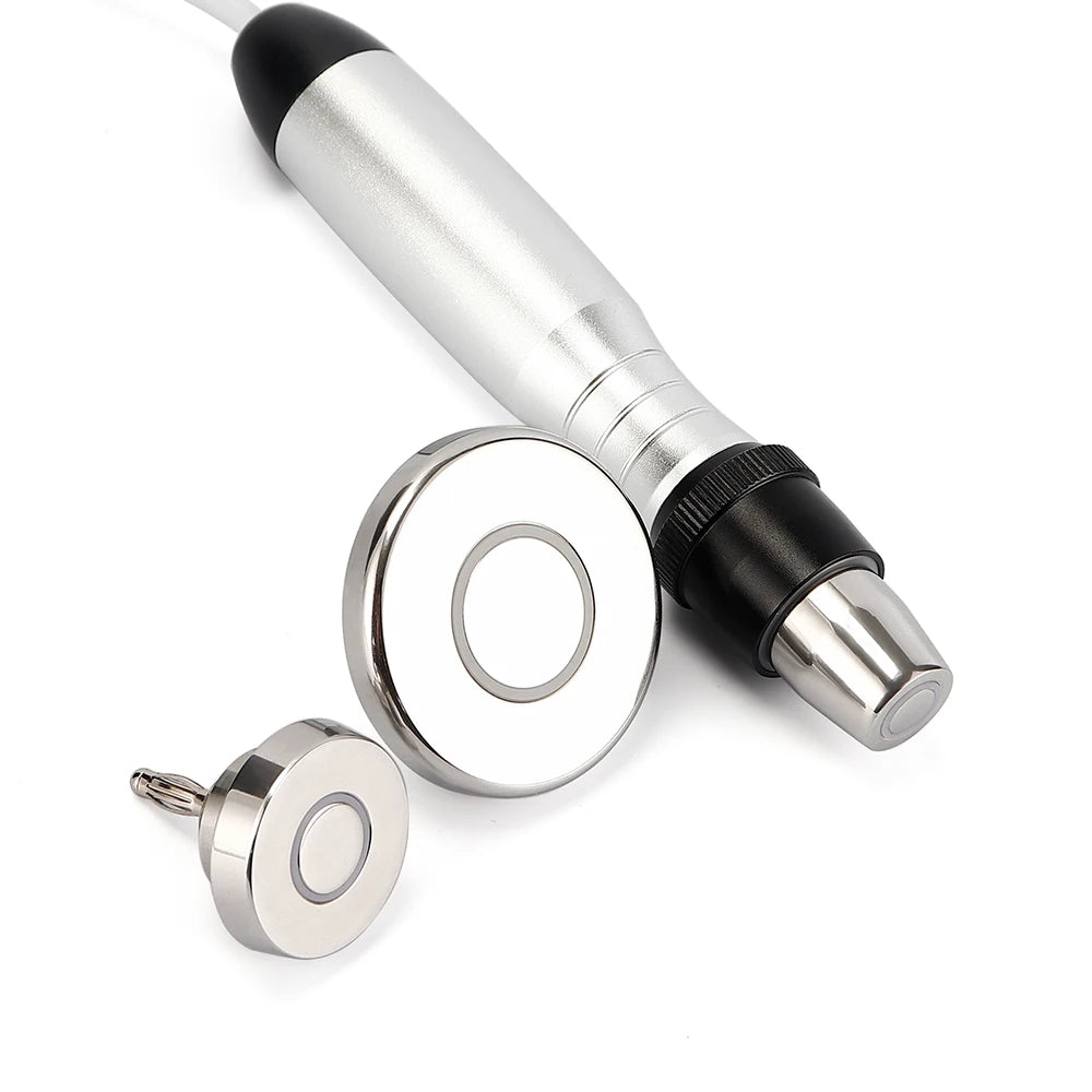 Silver handheld RF beauty device with one attached tip and two interchangeable round, metallic treatment heads.