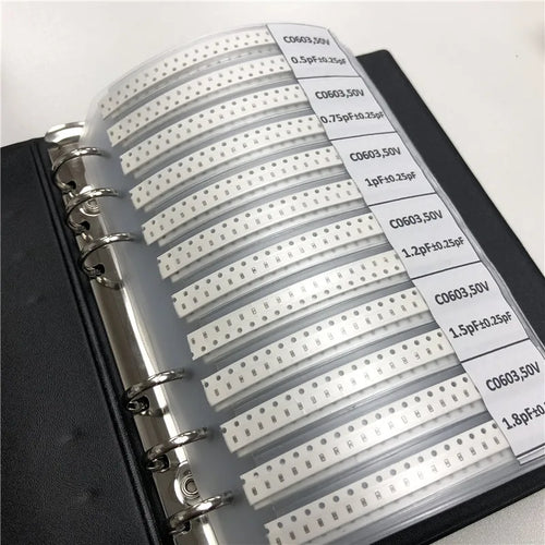 Capacitor sample binder with rows of white label strips showing printed component values