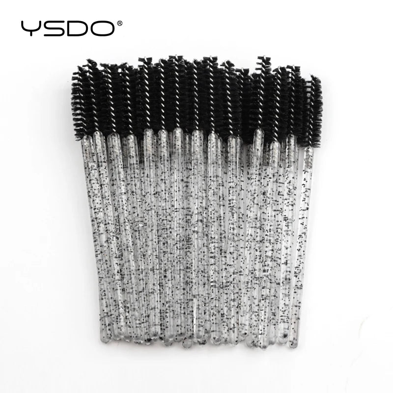 Disposable eyelash mascara brushes with black bristles and clear glittery plastic handles.