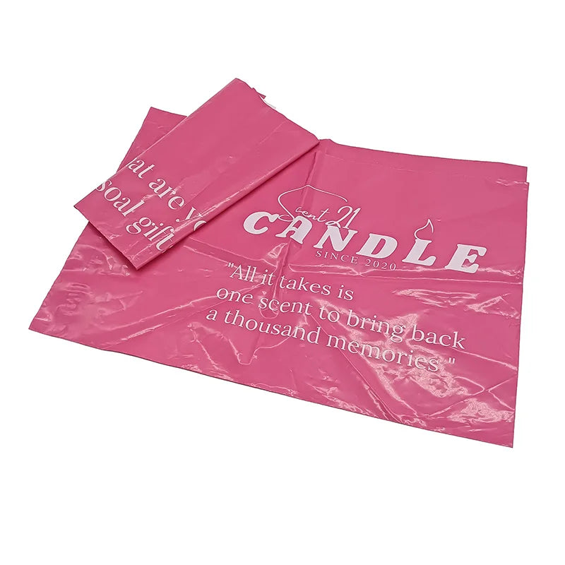 Pink poly mailer bags in a small stack with white “CANDLE” logo print
