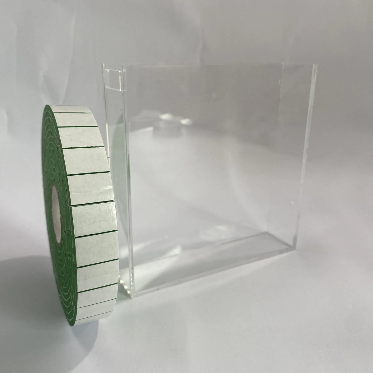Green EVA foam tape roll on clear stand, self-adhesive rectangular strips