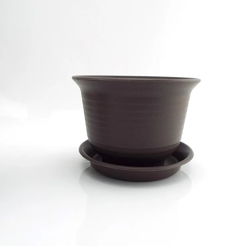 Dark gray plastic plant pot with attached saucer, angled view for shape details.