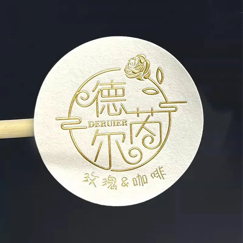 White round sticker label with gold DEKUEER logo and Chinese characters, embossed.