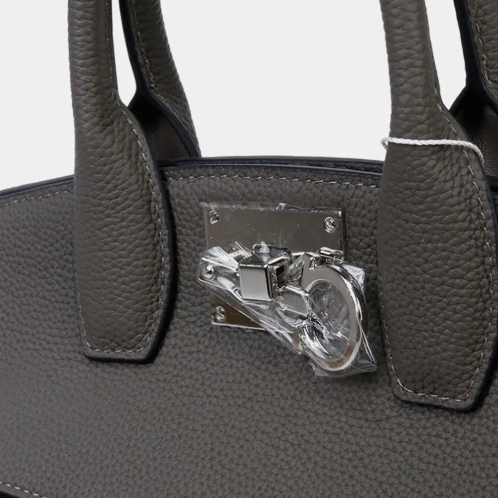 Grey pebbled genuine leather luxury trunk tote handbag with silver-tone metal clasp hardware.