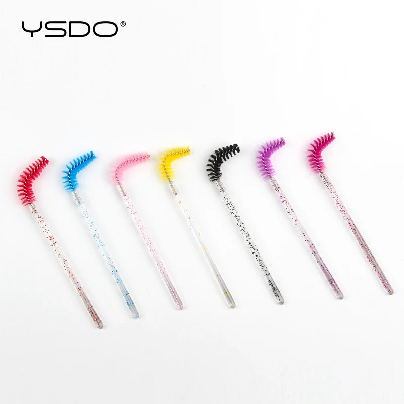Seven disposable eyelash brushes with bent, multicolored heads and glitter-infused clear plastic handles.