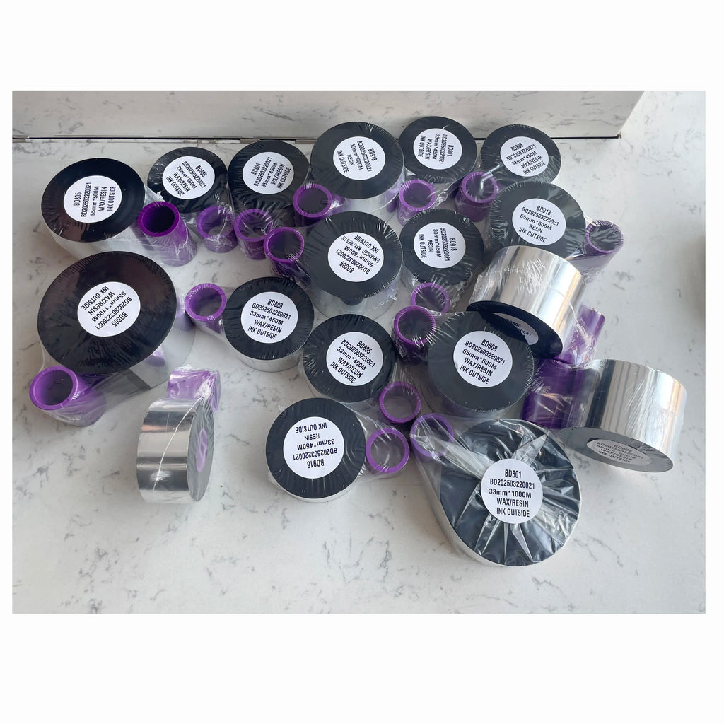 Assorted black thermal transfer ribbon rolls with purple inner cores and labels
