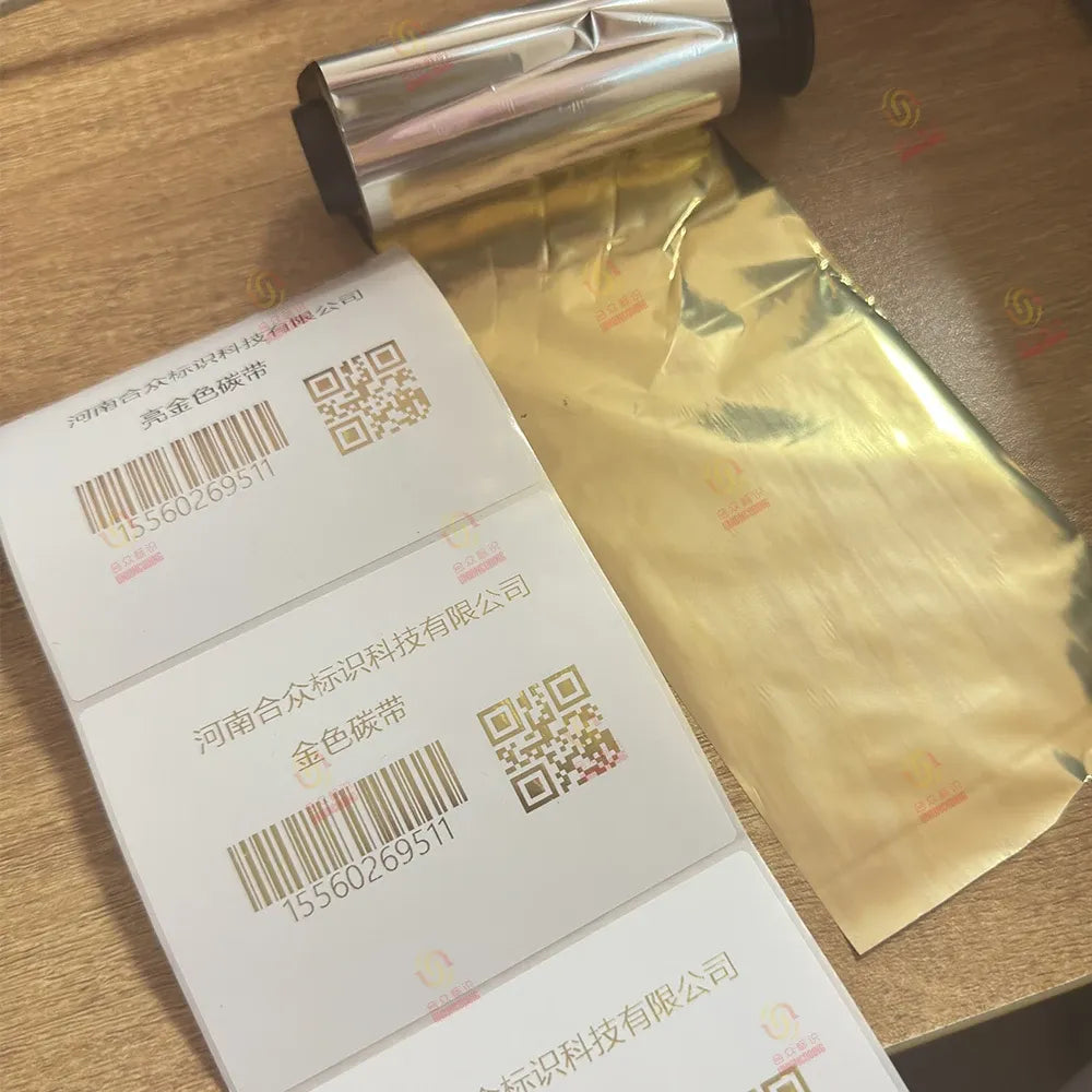 Gold-toned resin wax barcode printer ribbon roll, partially wrapped in foil