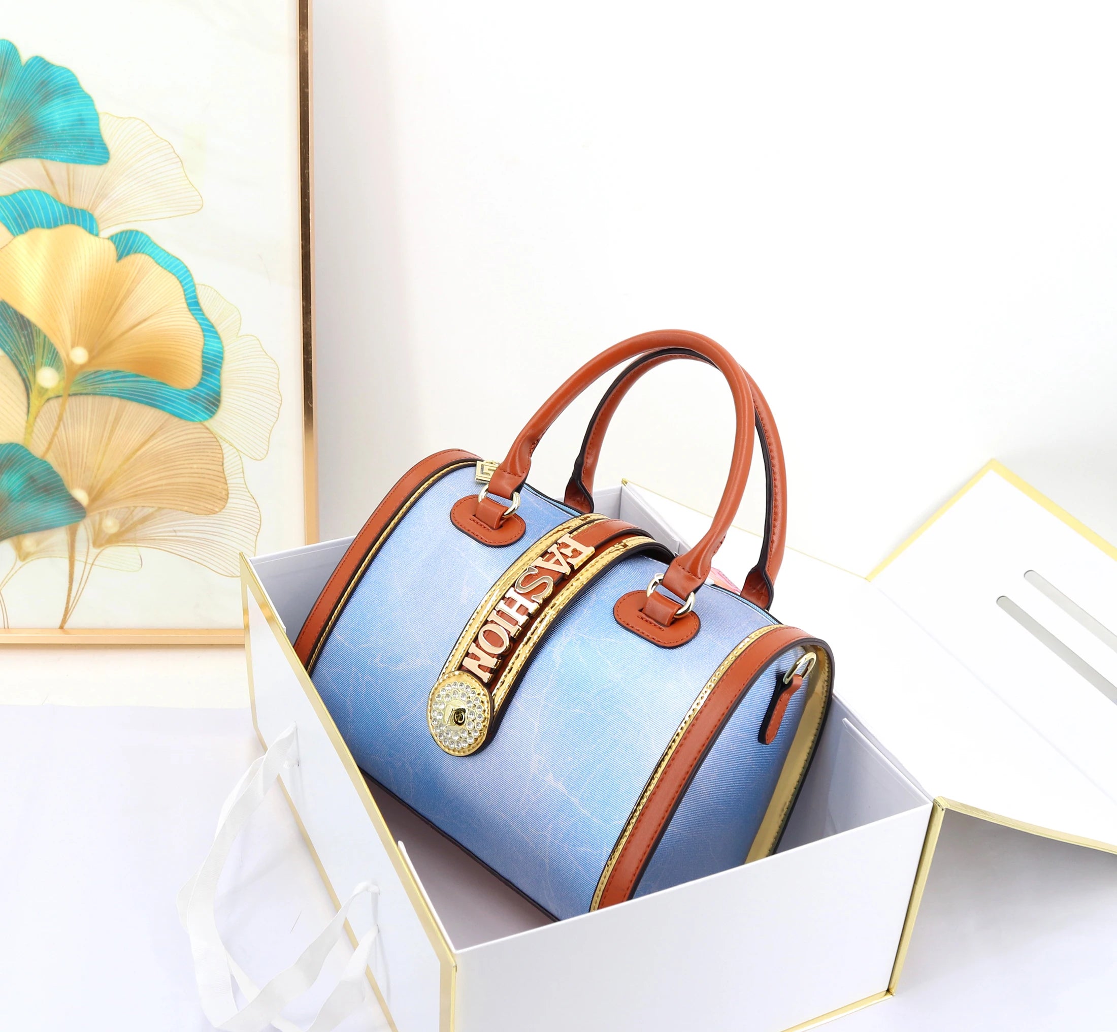 29cm blue marbled trunk handbag with tan leather trim, gold "FASHION" hardware, and crystal embellishment.
