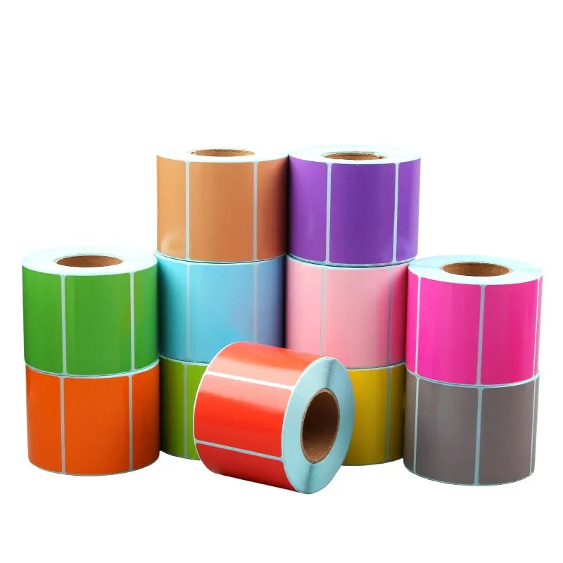 Assorted-color roll of direct thermal adhesive labels, stacked with matching label strips