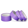 Purple masking tape rolls with paper backing, multiple rolls angled on white background.