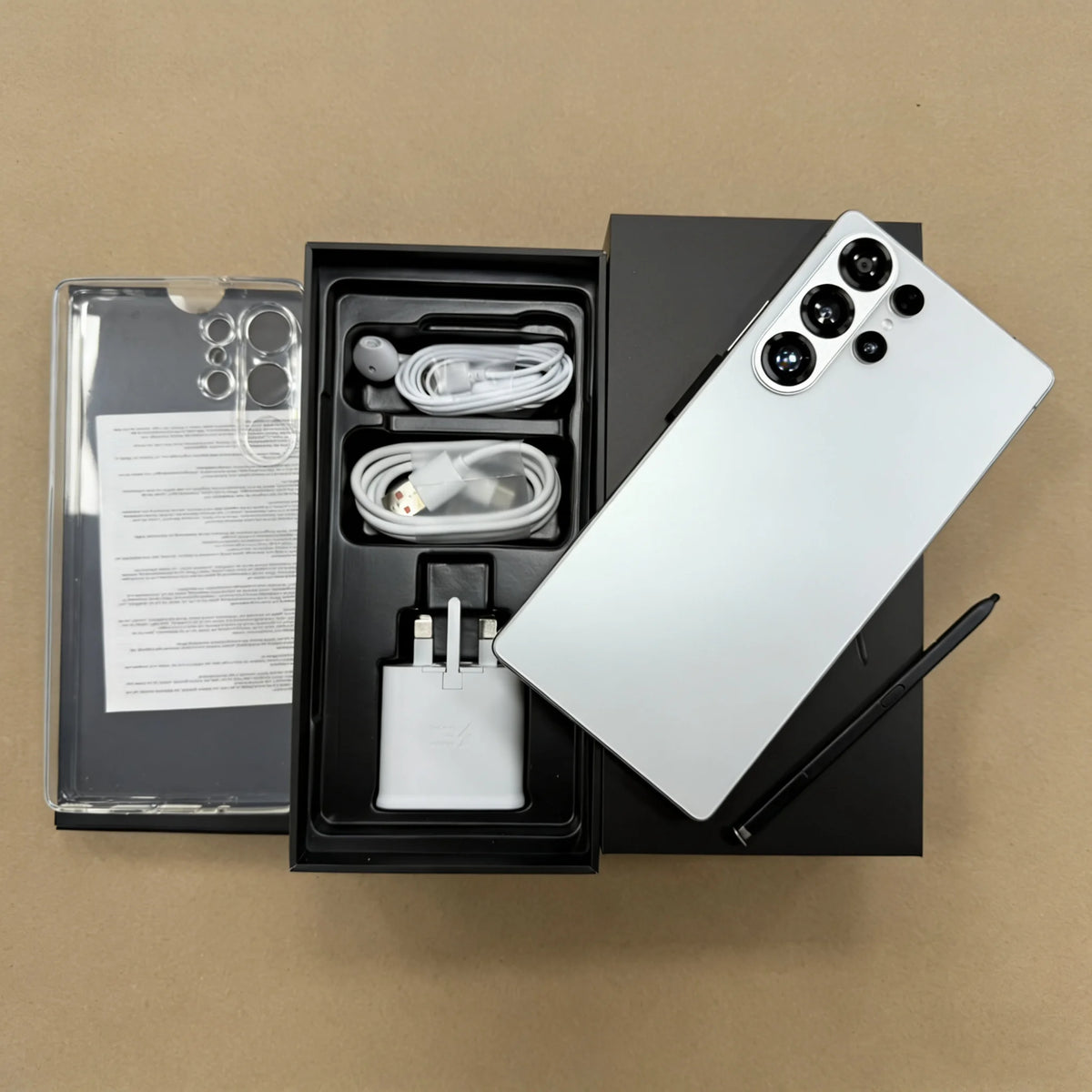 5G smartphone in packaging with accessories—cables, charger, and manuals—plus rear camera phone.