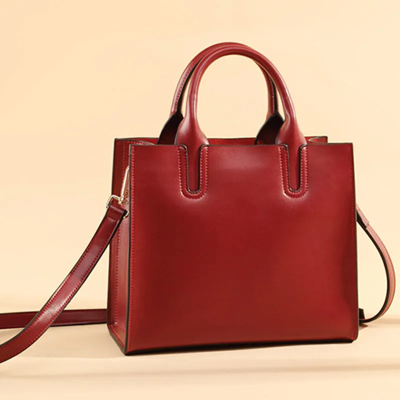 Red vintage genuine leather tote handbag with dual top handles and detachable shoulder strap, structured trunk style.