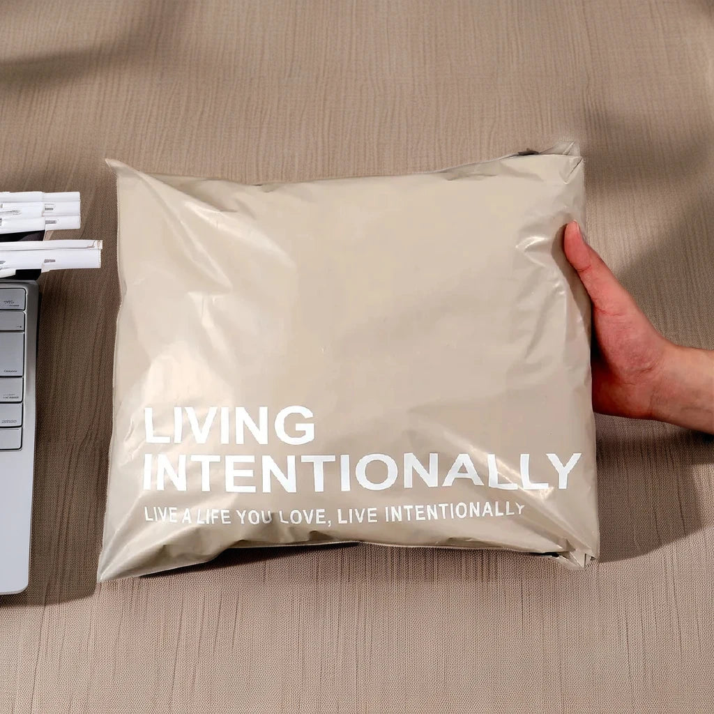 Cream poly mailer bag with white text “LIVING INTENTIONALLY”