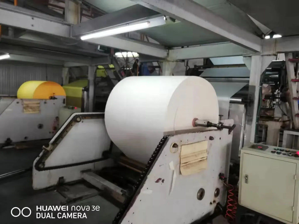 White masking tape jumbo roll on dispensing machine spindle