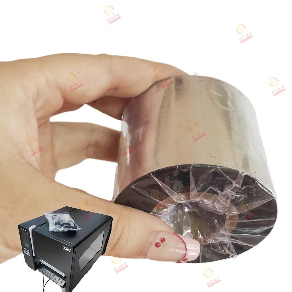 Hand holding black thermal transfer ribbon roll in clear plastic wrap