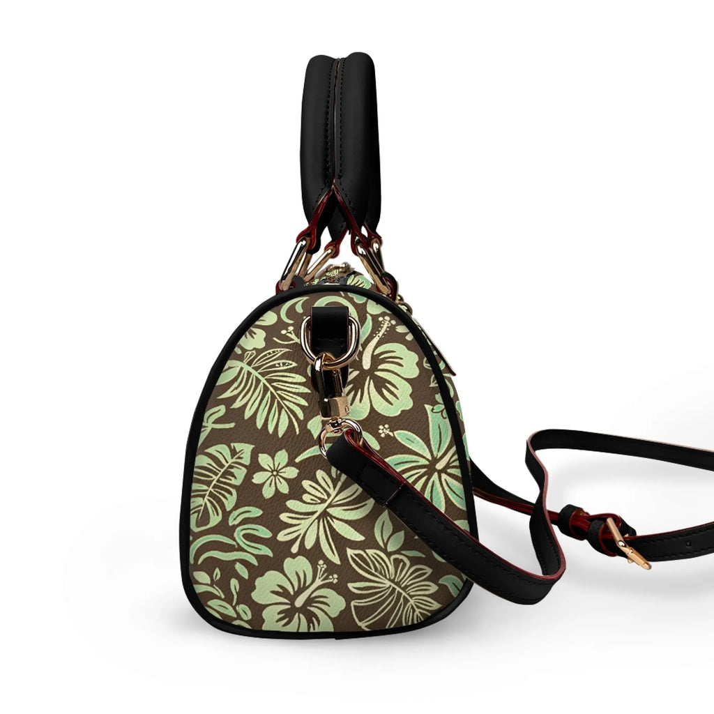 Pillow handbag with brown and mint tropical floral print, black leather trim, top handle, and adjustable shoulder strap.