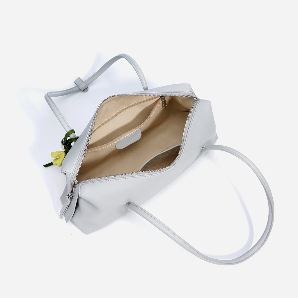 Grey genuine cowhide leather trunk handbag with top zipper, shoulder straps, and interior pockets.