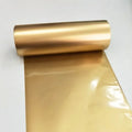 Matte gold metallic thermal transfer foil ribbon, tightly wound on a roll