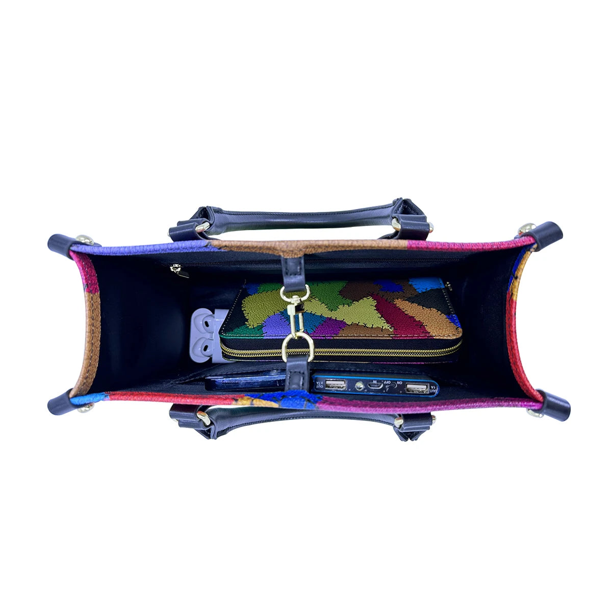Top-down view of colorful patchwork PU leather trunk handbag with black handles, spacious interior, and organized items.