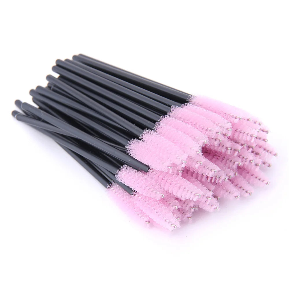 Disposable eyelash spoolies with black handles and light pink nylon brush heads for grooming lashes and brows.