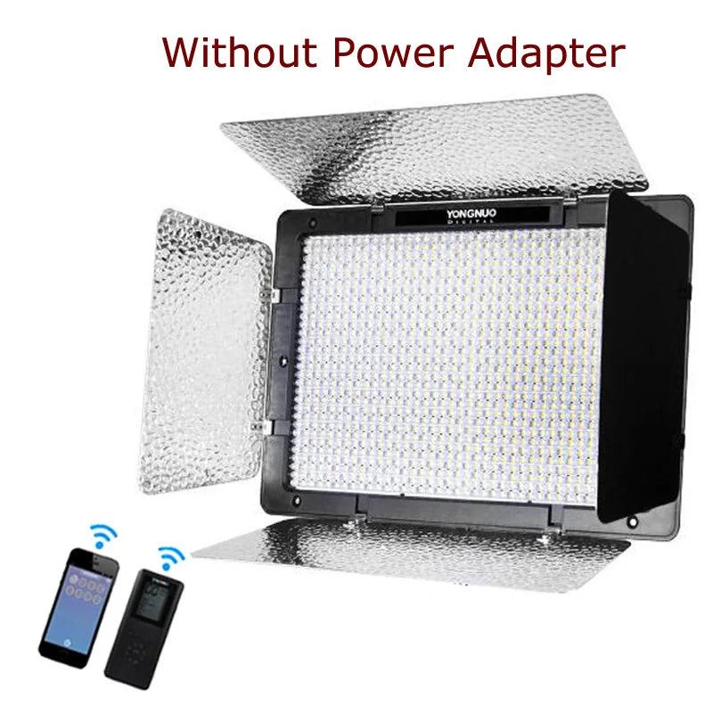 LED video light panel with reflective barn doors, remote control, and smartphone icon for wireless lighting control.